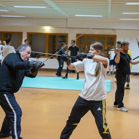 Eine Frau und ein Mann üben Schwertkampftechniken miteinander