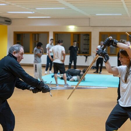 Eine Frau und ein Mann üben Schwertkampftechniken miteinander